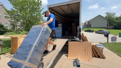 Kentuckiana mover loading wrapped furniture onto a moving truck