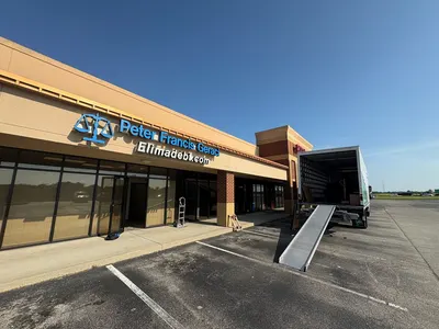 Moving truck staged with a ramp outside a commercial storefront