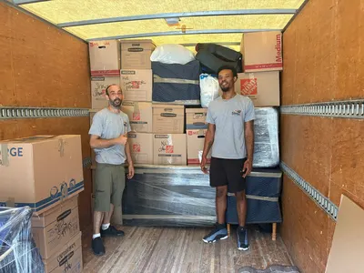 Kentuckiana movers standing with a fully loaded moving truck