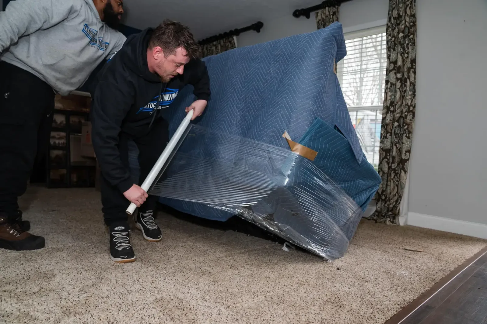 Kentuckiana movers wrapping furniture inside a home